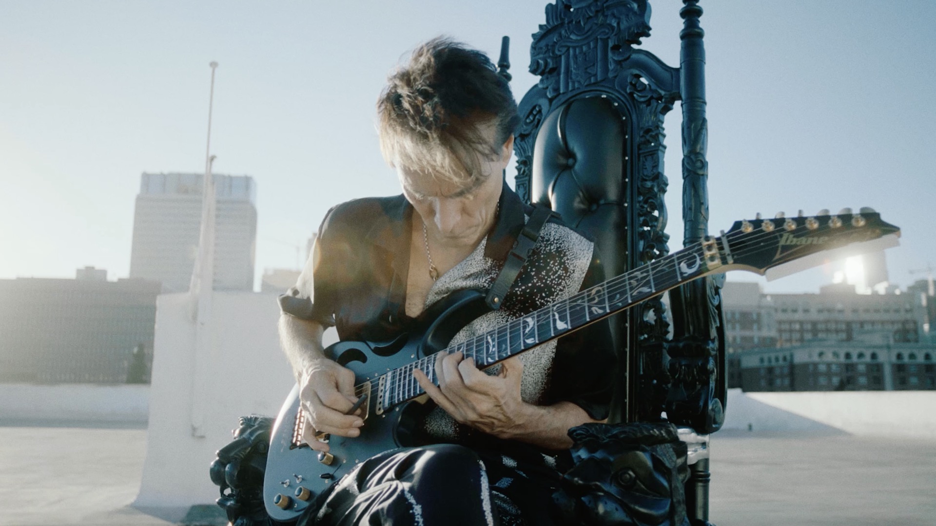 Steve Vai on his throne with his Ibanez guitar on Polyphia music video for Ego Death